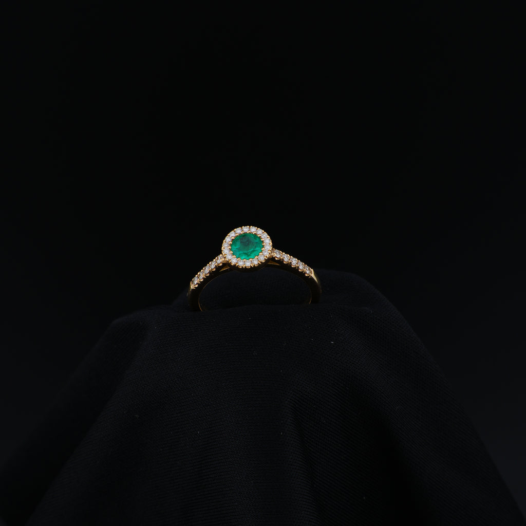 Anillo Halo en Oro Amarillo, talla 6¾, con esmeralda redonda y 29 diamantes.