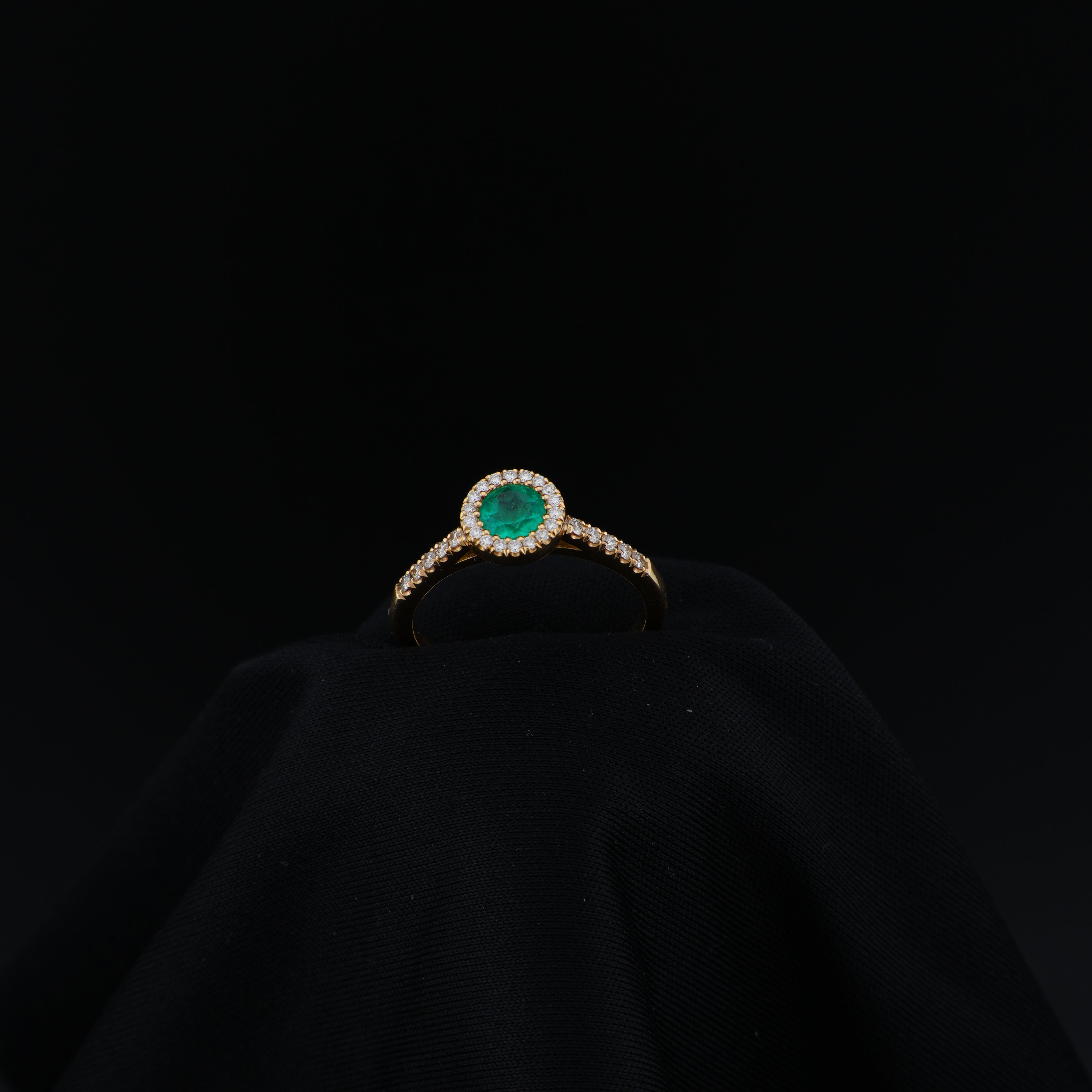 Anillo Cluster en Oro Amarillo, talla 6¾, con esmeralda redonda y 29 diamantes.
