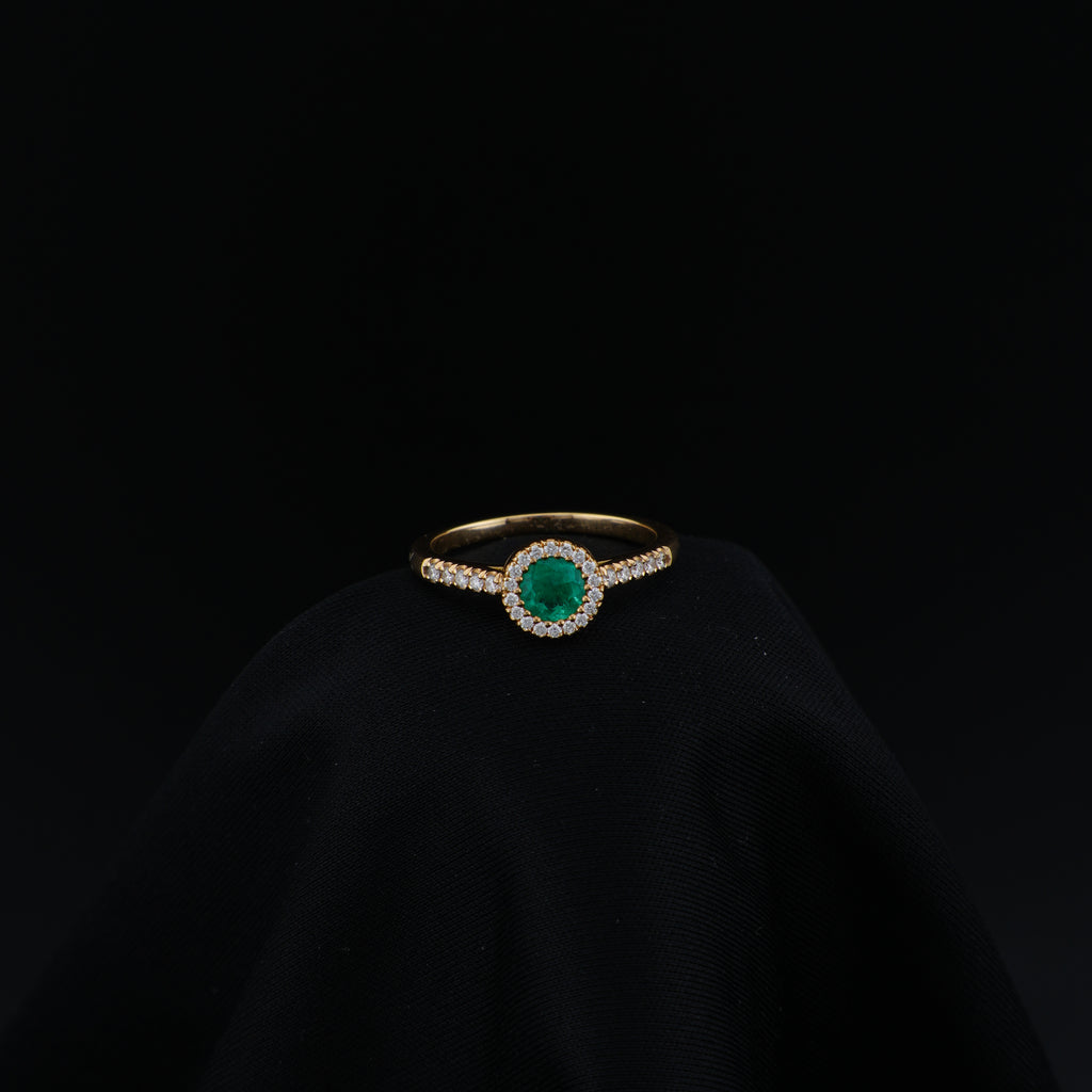 Anillo Halo en Oro Amarillo, talla 6¾, con esmeralda redonda y 29 diamantes.