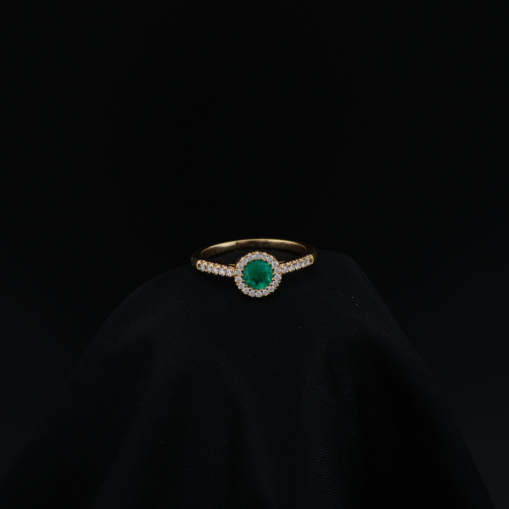 Anillo Halo en Oro Amarillo, talla 6¾, con esmeralda redonda y 29 diamantes.