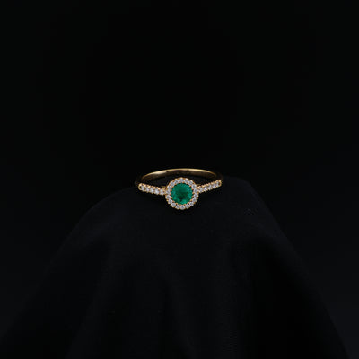 Anillo Halo en Oro Amarillo, talla 6¾, con esmeralda redonda y 29 diamantes.