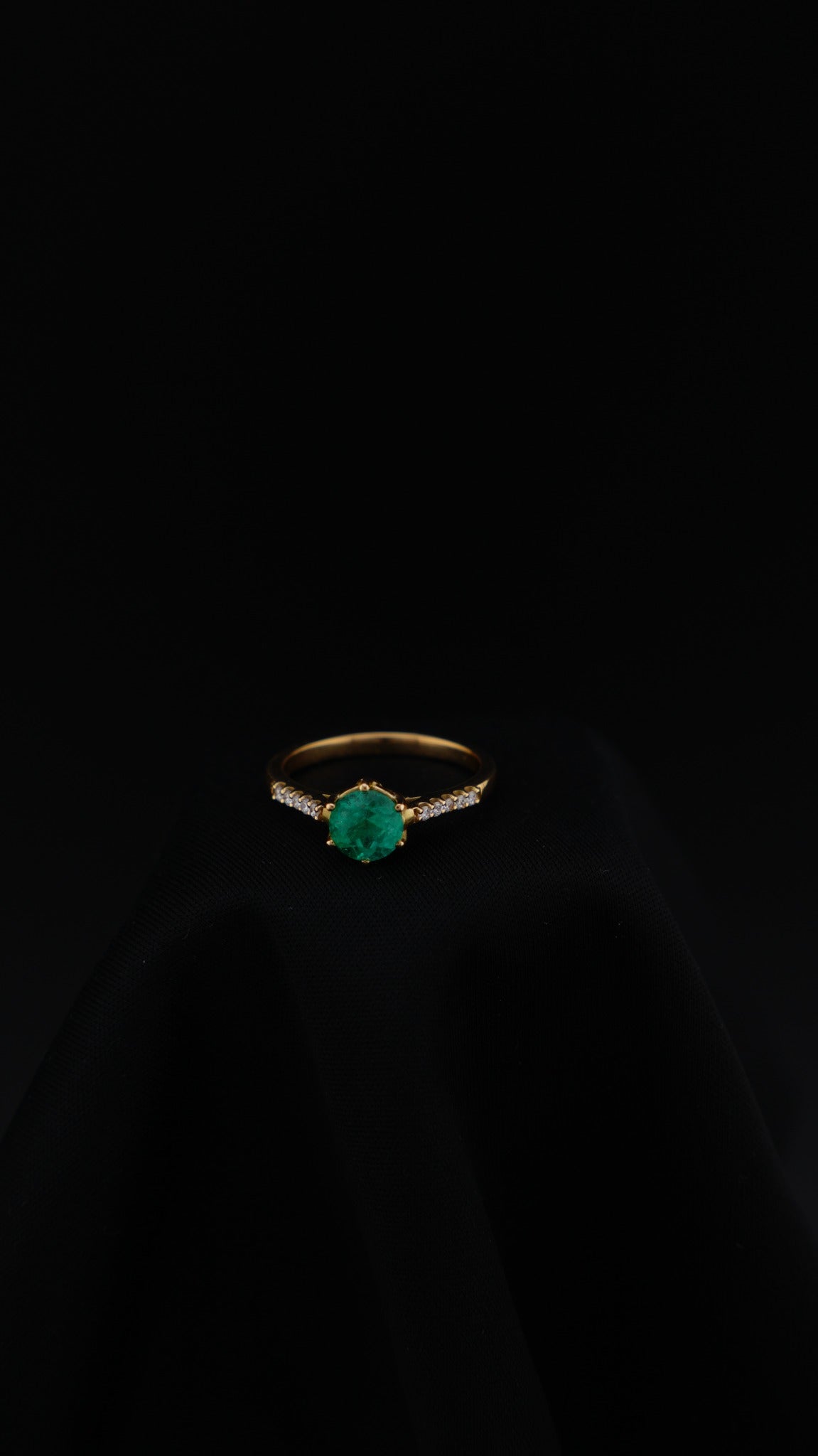 Anillo Esencia en oro amarillo 18K con esmeralda natural redonda y diamantes naturales